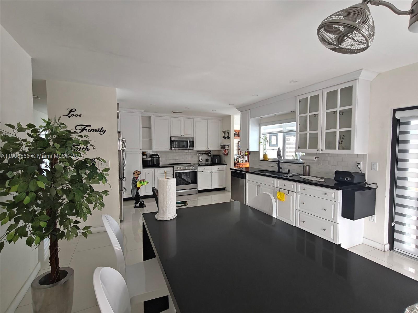 14444 Southwest 107th Terrace Miami, FL 33186 - Photo 15 of 73 a kitchen with stainless steel appliances a stove a refrigerator a sink a stove and white cabinets