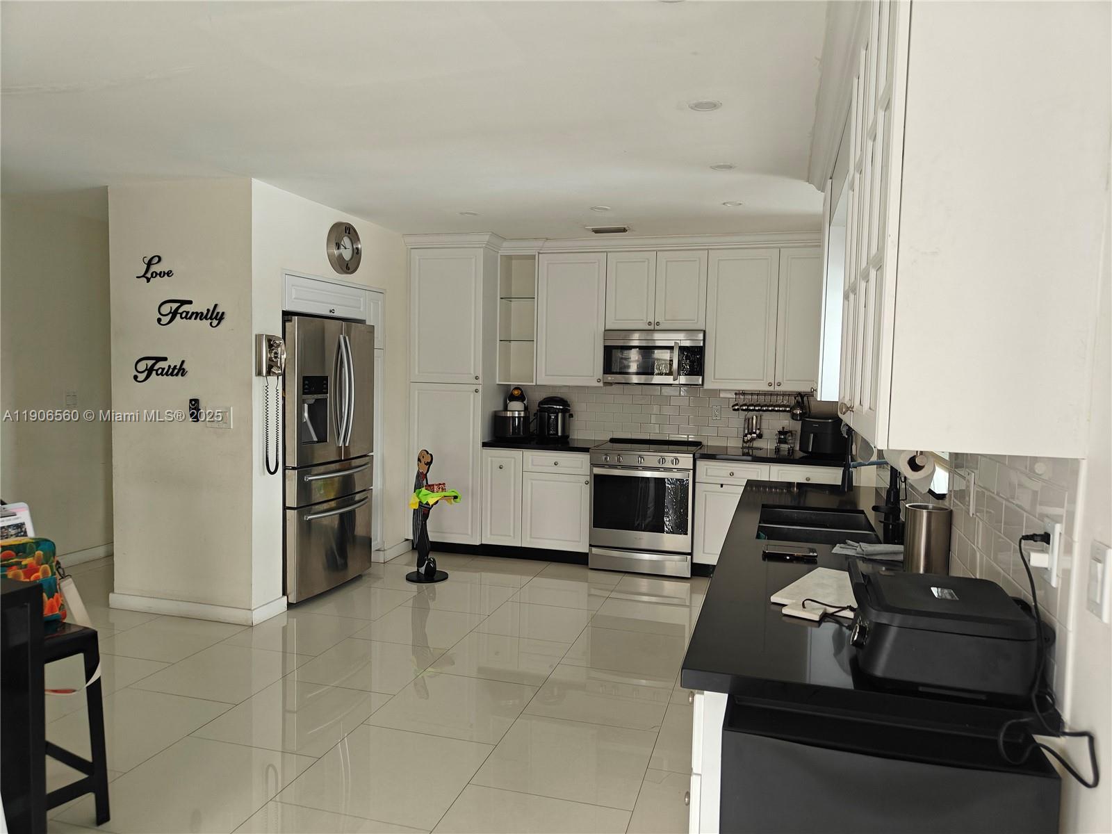 14444 Southwest 107th Terrace Miami, FL 33186 - Photo 10 of 73 a kitchen with kitchen island a counter top space a refrigerator and cabinets