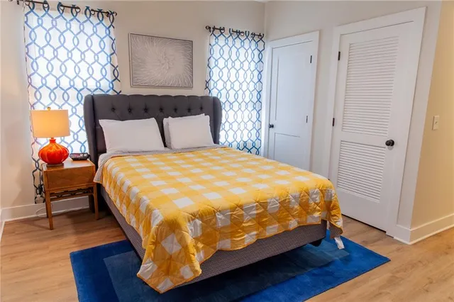 a bed sitting in a bedroom next to a window with wooden floor
