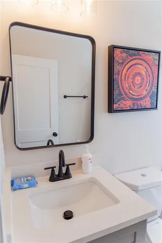 a bathroom with a toilet a sink and mirror