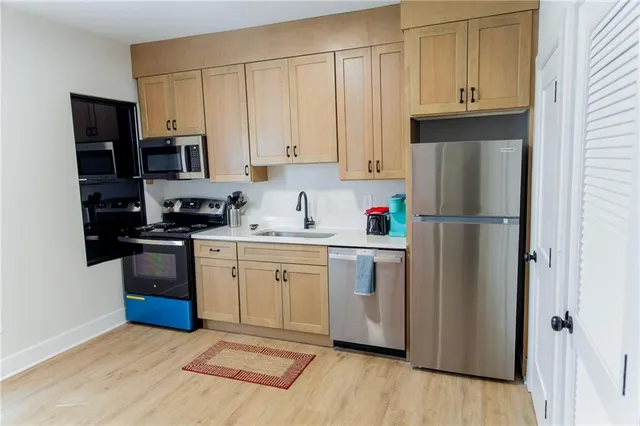 a kitchen with stainless steel appliances granite countertop a sink and a white wooden cabinets