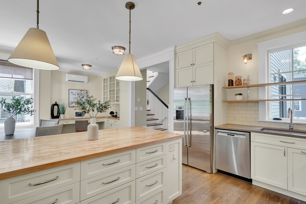 2 Percy Place Cambridge, MA 02139 - Photo 15 of 37 a kitchen with stainless steel appliances granite countertop a sink a refrigerator and white cabinets