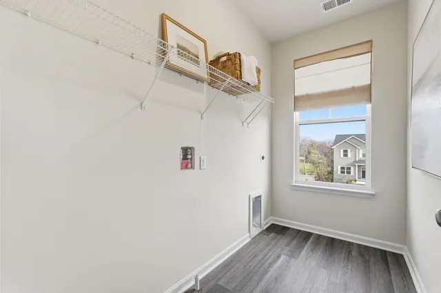 a view of hallway with window and wooden floor