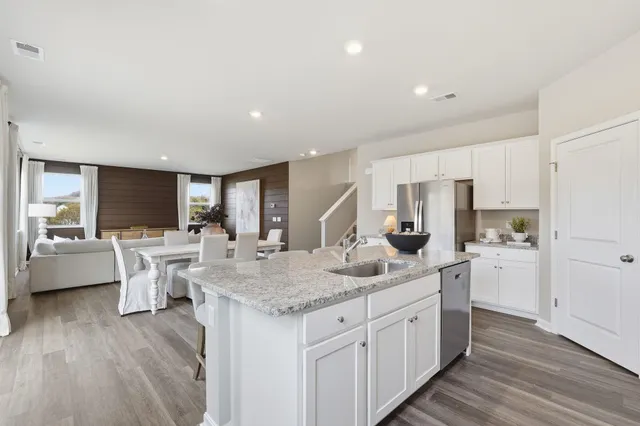 a kitchen with white cabinets and sink