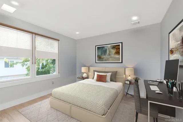 a bedroom with a large bed and a flat tv screen on dresser