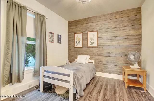 a bedroom with a bed and wooden floor