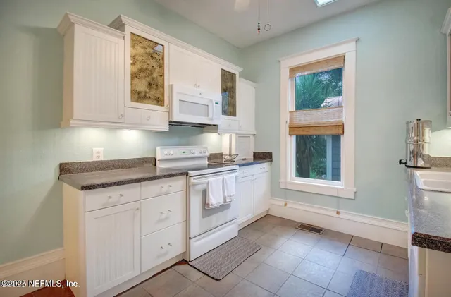 a kitchen with granite countertop a stove a sink and a microwave