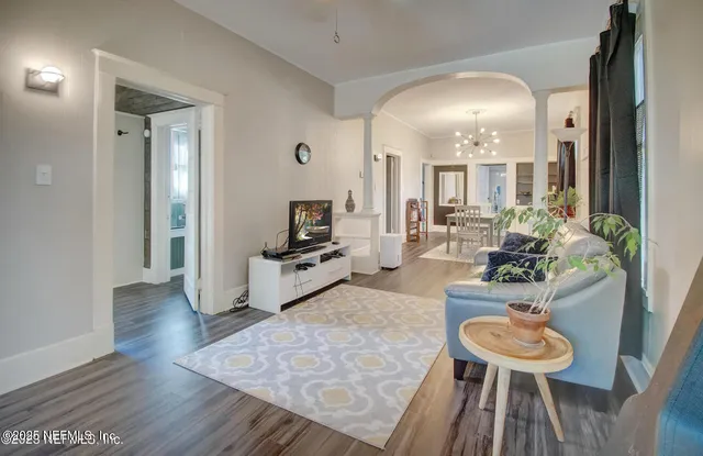 a living room with furniture and a wooden floor