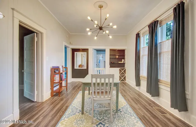 a view of a dining room with furniture a chandelier and wooden floor