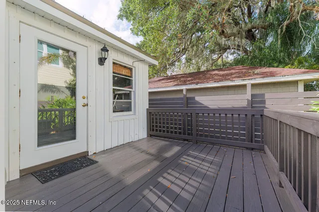 a view of a balcony with wooden floor and fence and a bench