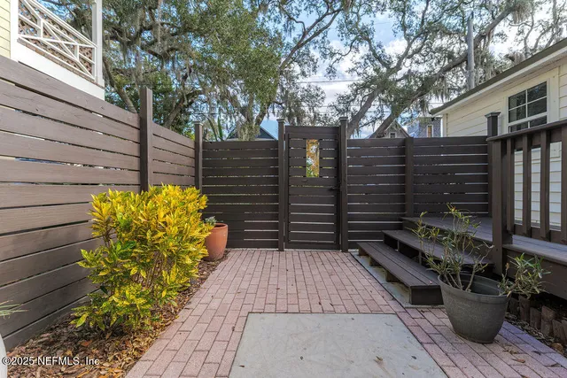 a view of a pathway with an umbrella and wooden fence