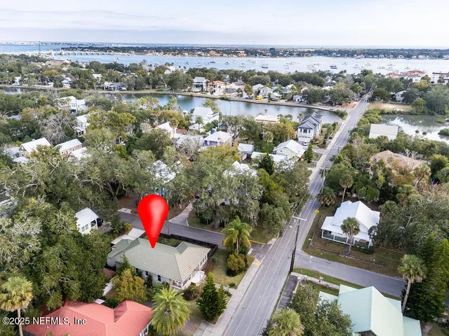an aerial view of a house with a yard and lake view