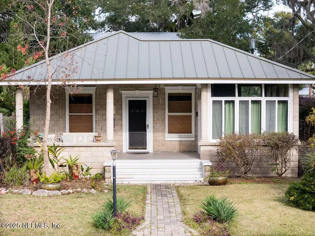 a view of a house with a yard and sitting area