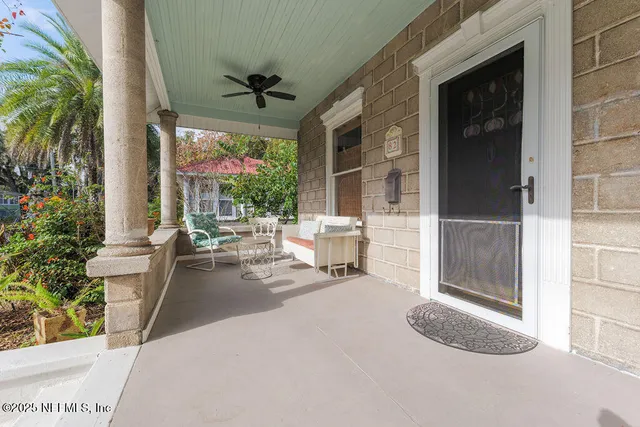 a living room with patio furniture and a potted plant