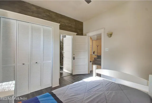 a bedroom with a bed and wooden floor