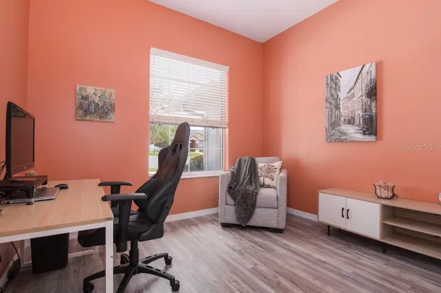 a spacious bedroom with a bed a chandelier and a large window