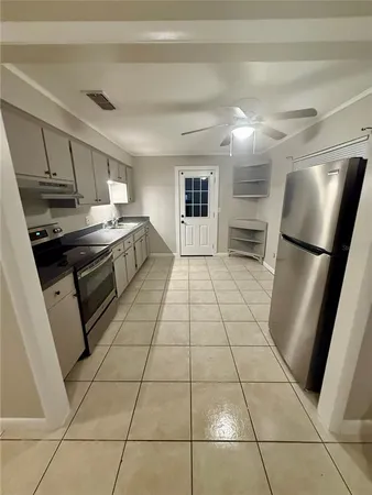 a kitchen with granite countertop a refrigerator a sink a stove a microwave and cabinets