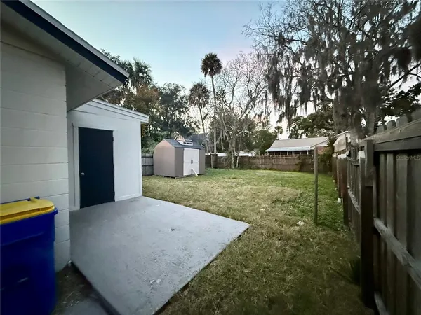 a view of a house with backyard and a tree