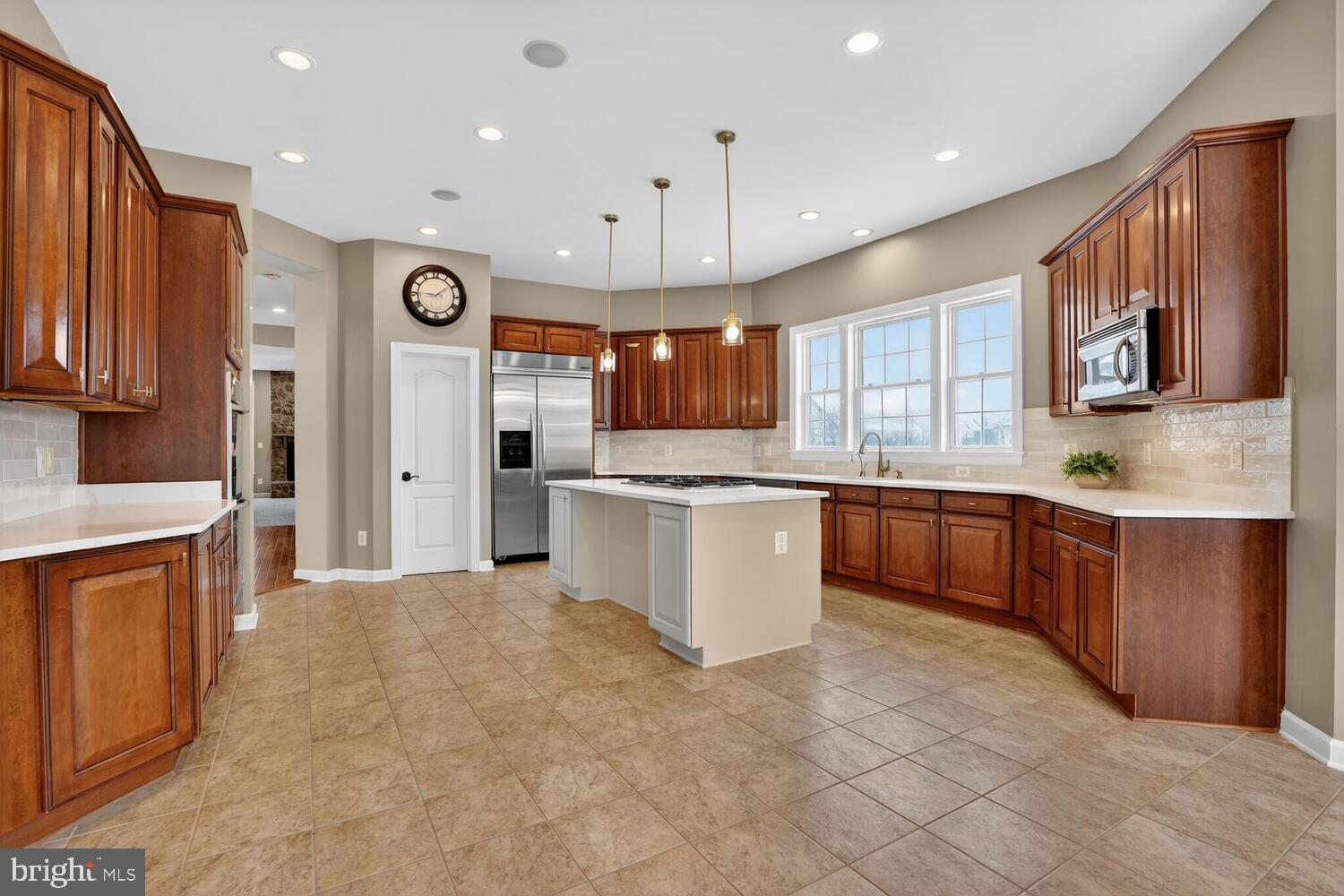 43024 La Riva Drive Ashburn, VA 20148 - Photo 11 of 63 a large kitchen with stainless steel appliances kitchen island granite countertop a stove sink and cabinets