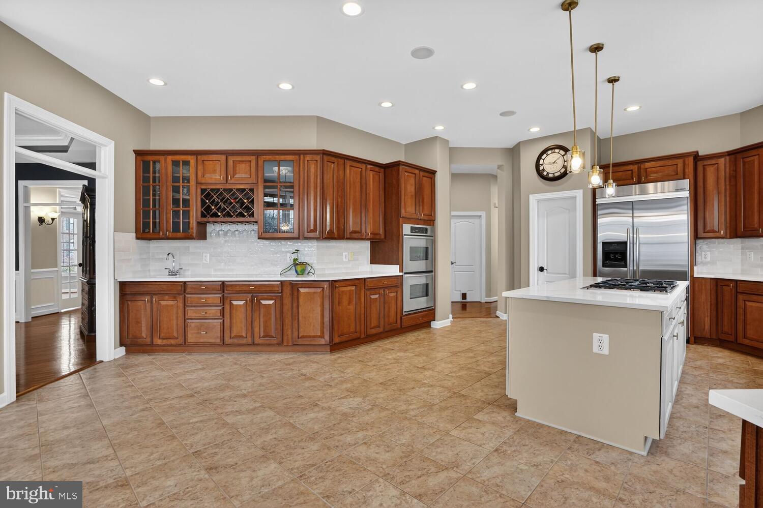 43024 La Riva Drive Ashburn, VA 20148 - Photo 13 of 63 a large kitchen with a large counter top a sink a counter space and cabinets