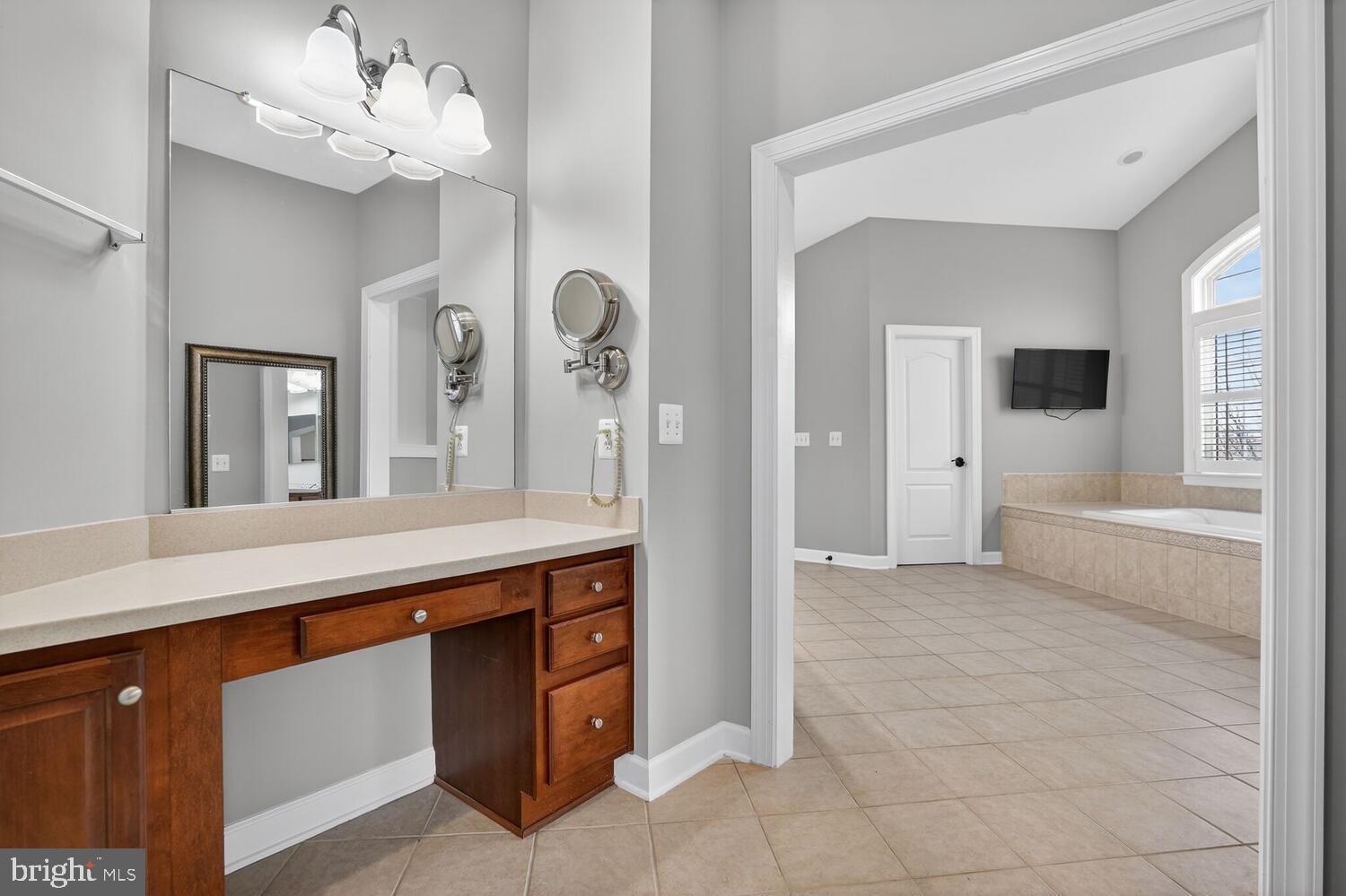43024 La Riva Drive Ashburn, VA 20148 - Photo 40 of 63 a spacious bathroom with a granite countertop sink a mirror and a bathtub