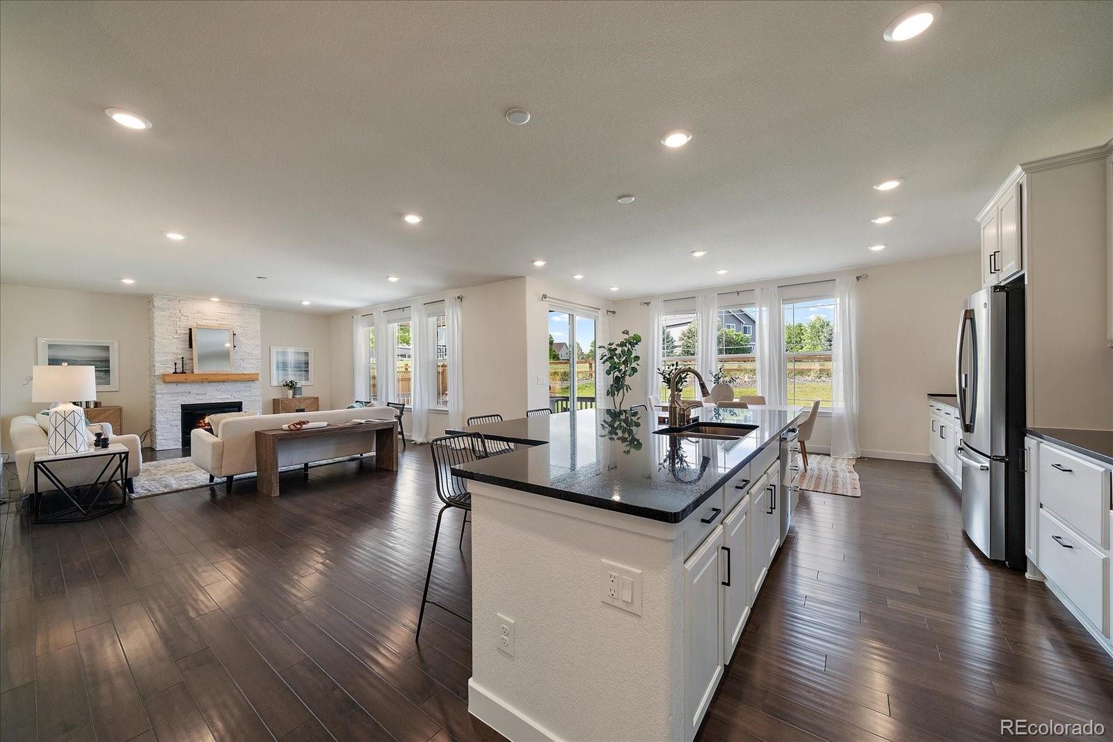 16062 Red Bud Loop Parker, CO 80134 - Photo 12 of 36 a large kitchen with stainless steel appliances lots of counter space and windows