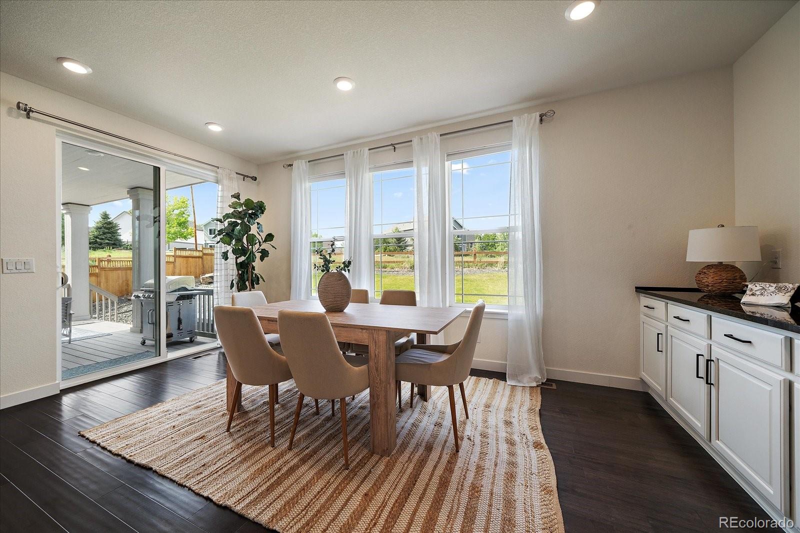 16062 Red Bud Loop Parker, CO 80134 - Photo 13 of 36 a view of a dining room with furniture and wooden floor