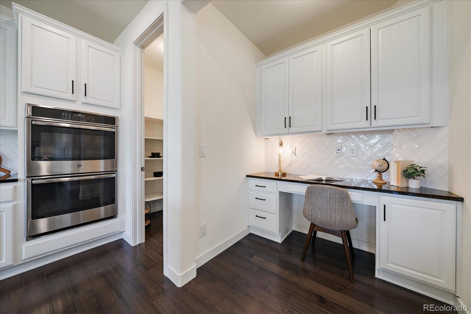16062 Red Bud Loop Parker, CO 80134 - Photo 14 of 36 a kitchen with granite countertop white cabinets and stainless steel appliances