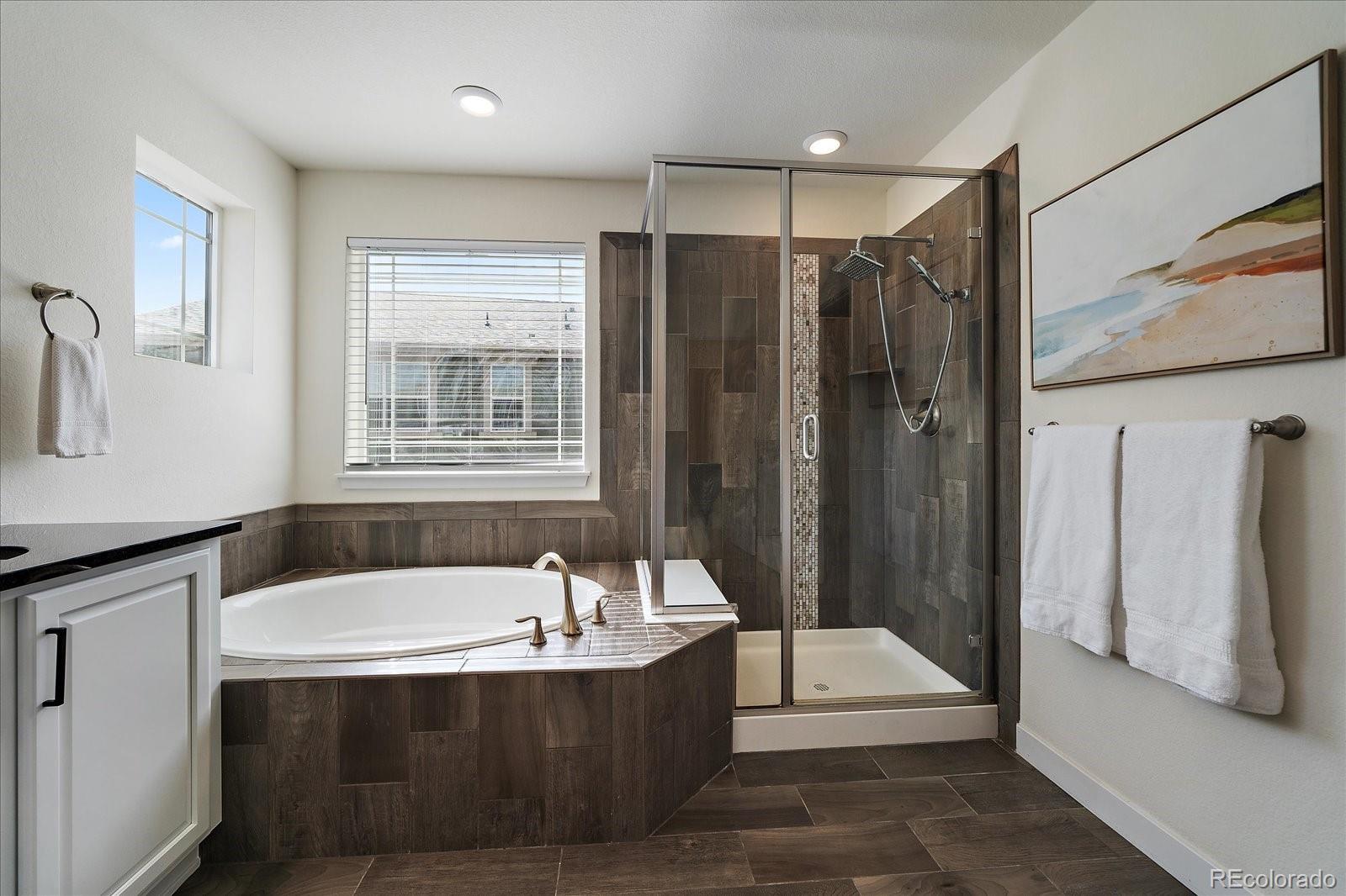 16062 Red Bud Loop Parker, CO 80134 - Photo 25 of 36 a bathroom with a tub a sink and a shower