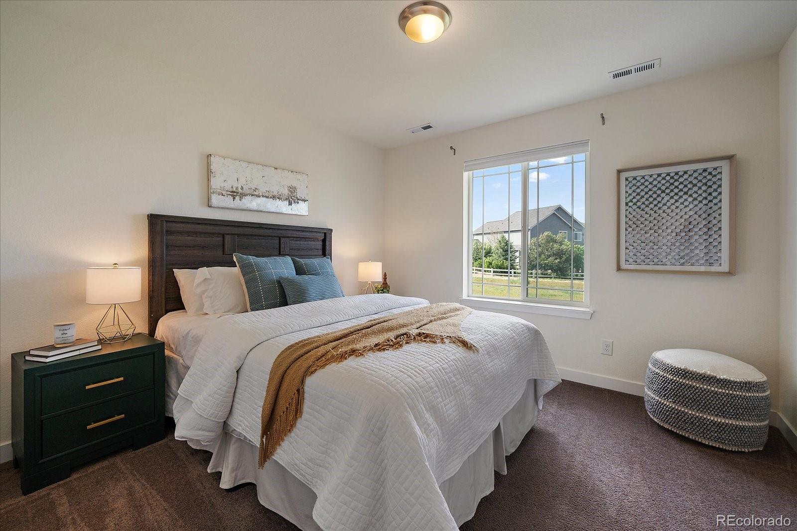 16062 Red Bud Loop Parker, CO 80134 - Photo 27 of 36 a bedroom with a bed and a lamp