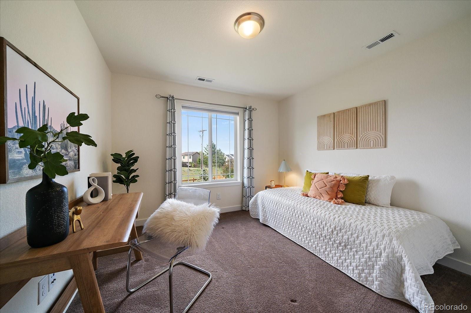 16062 Red Bud Loop Parker, CO 80134 - Photo 28 of 36 a bedroom with furniture and a potted plant