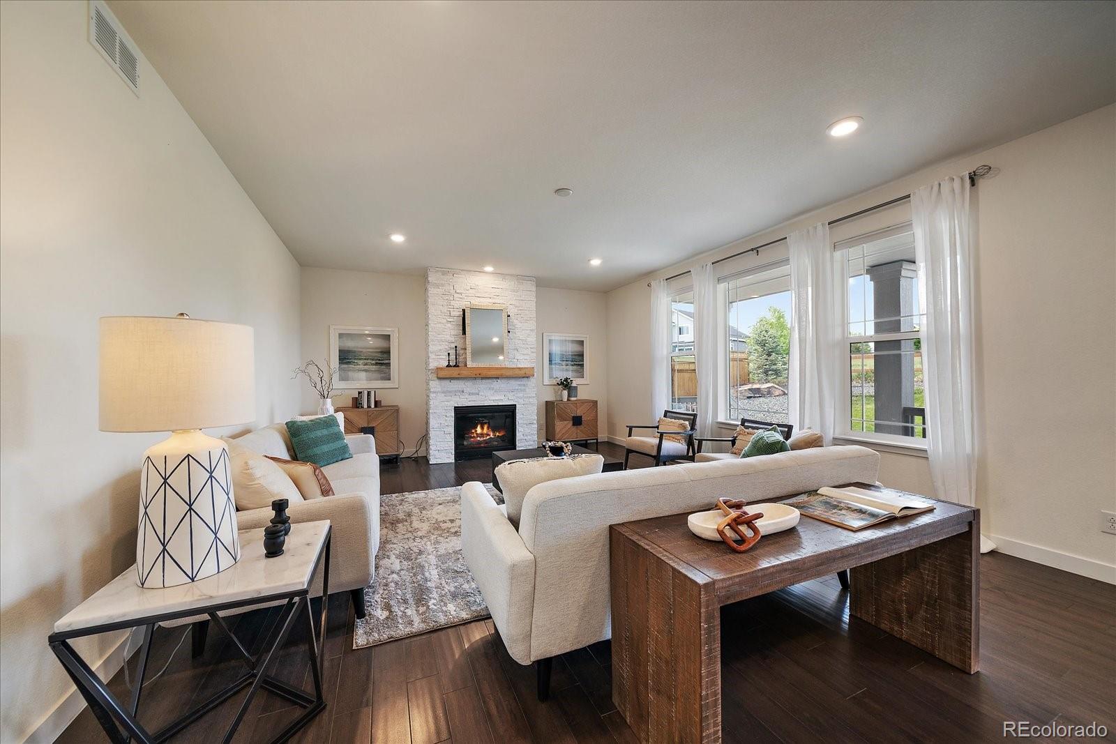 16062 Red Bud Loop Parker, CO 80134 - Photo 3 of 36 a living room with furniture large window and wooden floor