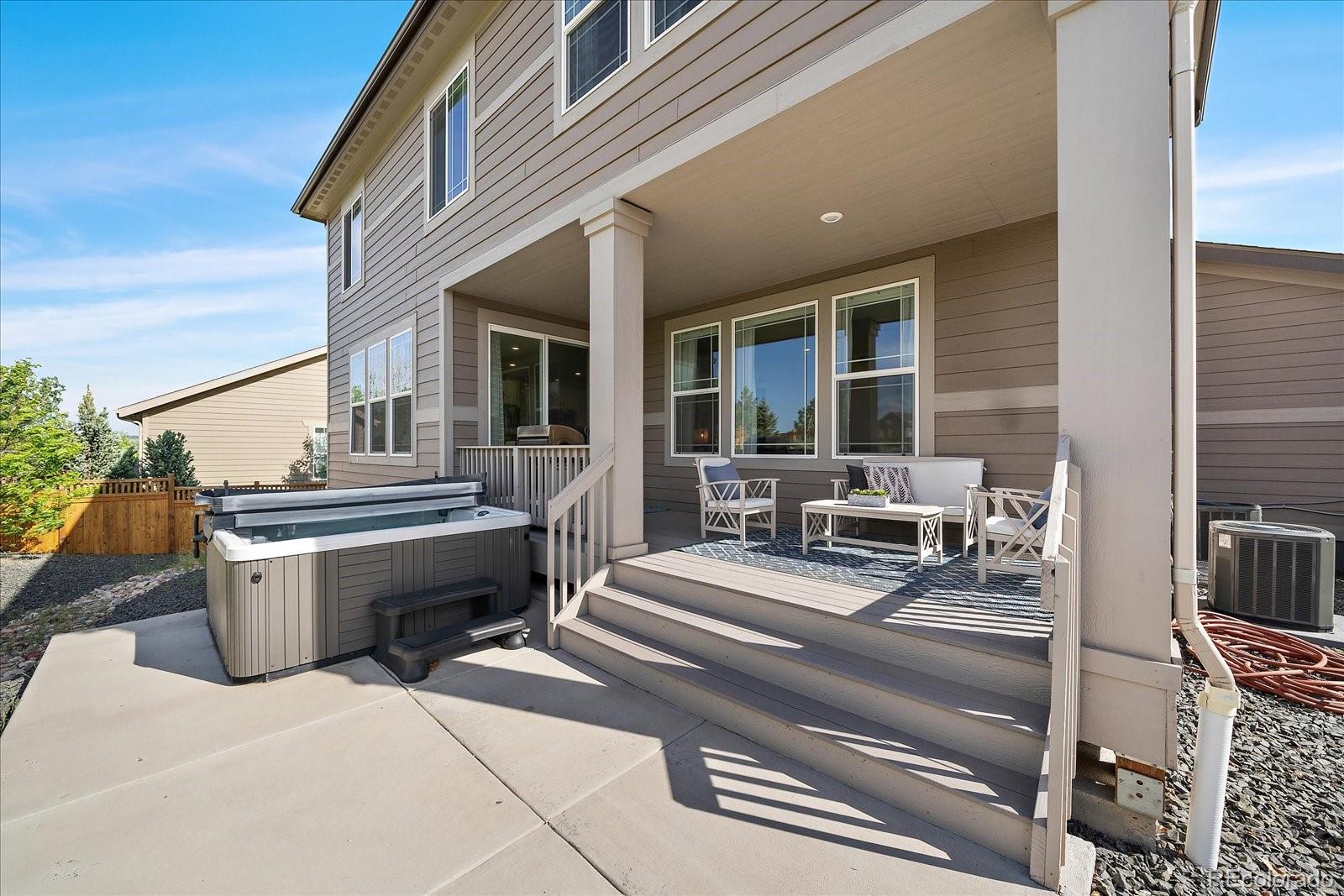 16062 Red Bud Loop Parker, CO 80134 - Photo 32 of 36 a view of a patio with table and chairs barbeque oven and floor to ceiling window