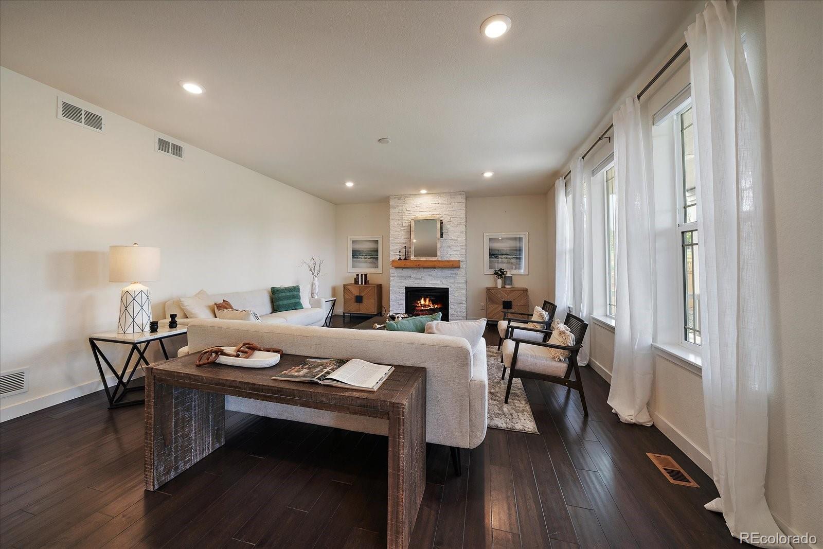 16062 Red Bud Loop Parker, CO 80134 - Photo 4 of 36 a living room with furniture a fireplace and wooden floor
