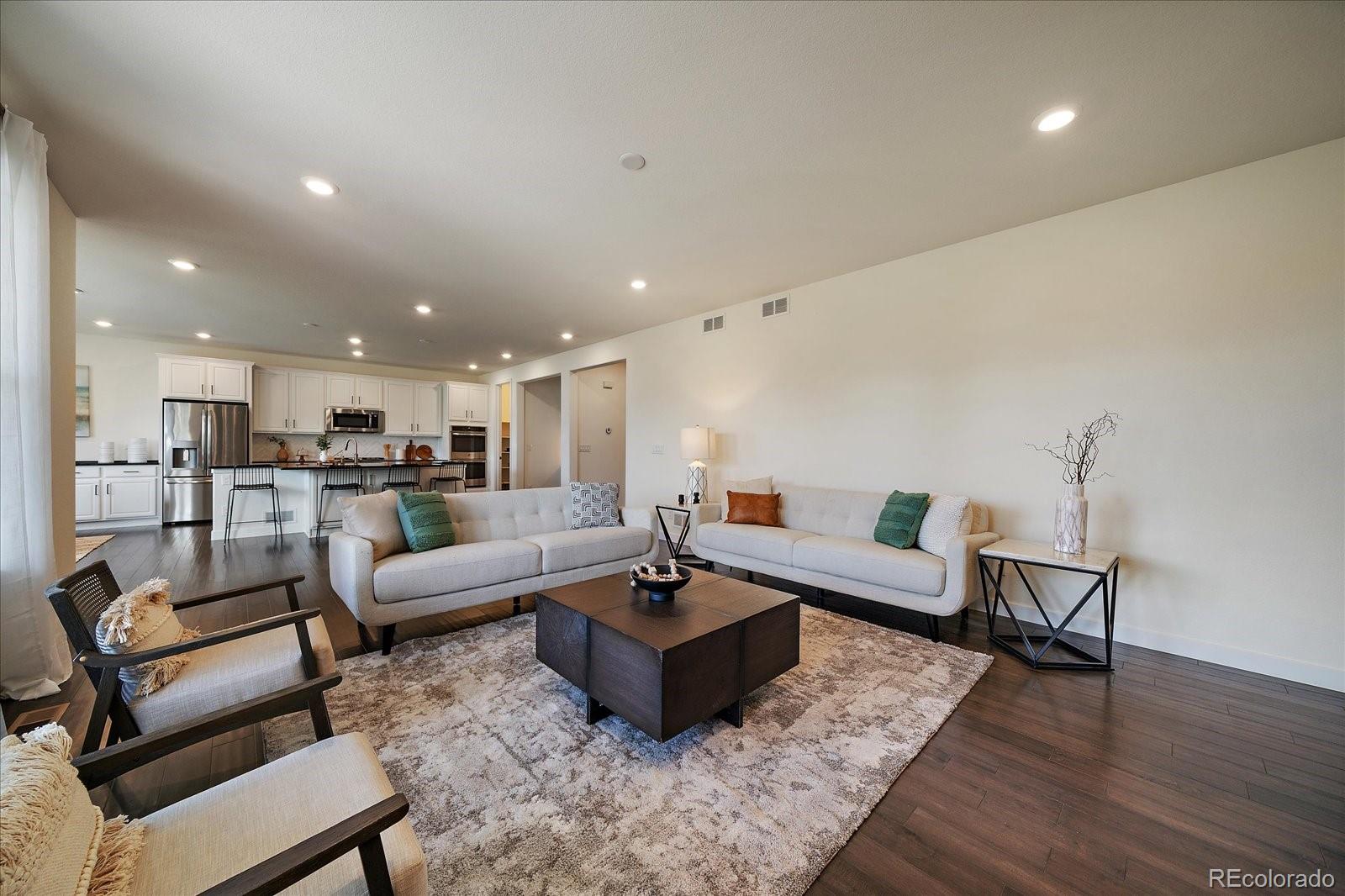 16062 Red Bud Loop Parker, CO 80134 - Photo 6 of 36 a living room with furniture and view of kitchen