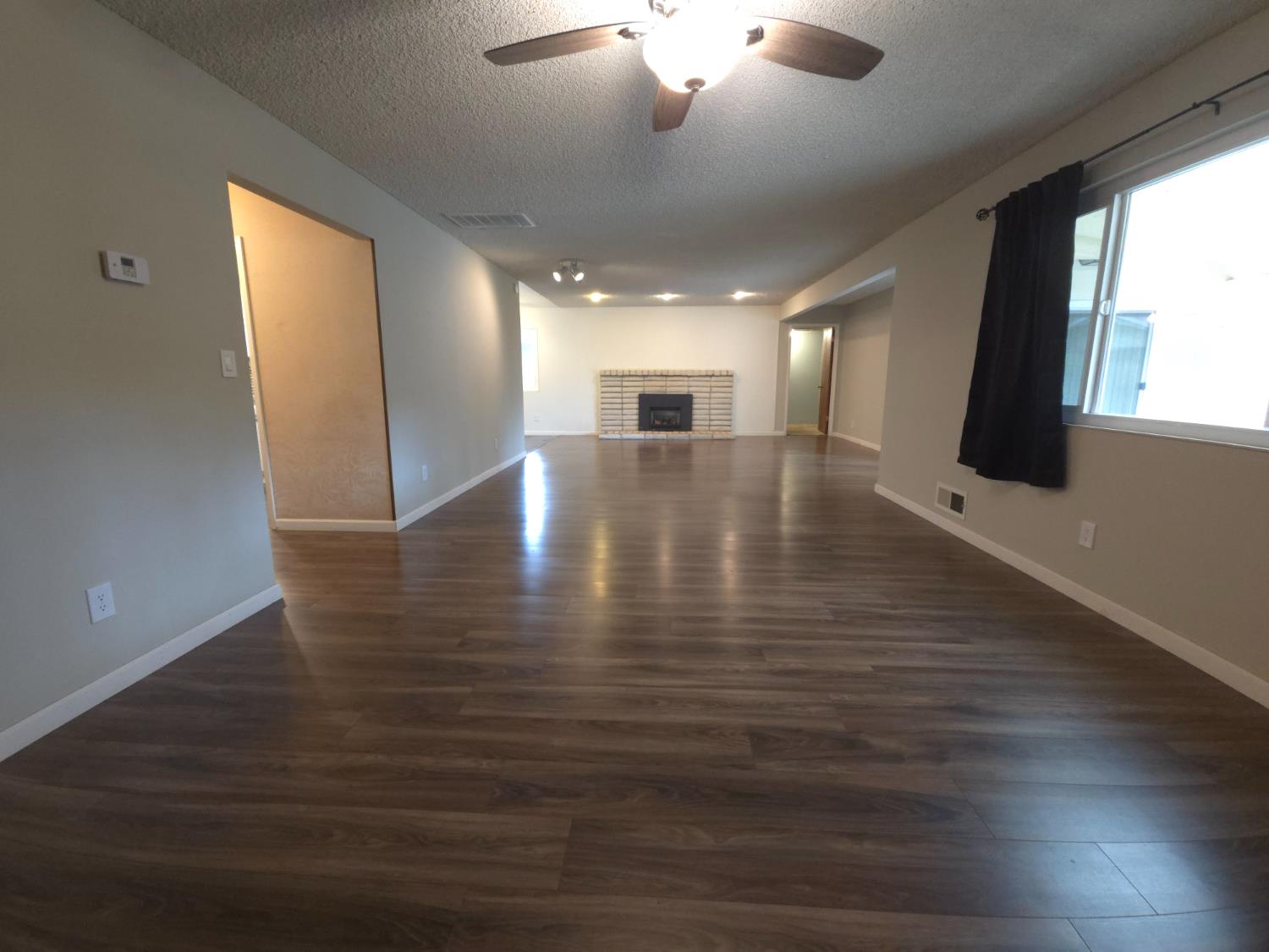1601 Jacquelyn Way Modesto, CA 95355 - Photo 4 of 23 an empty room with wooden floor and windows