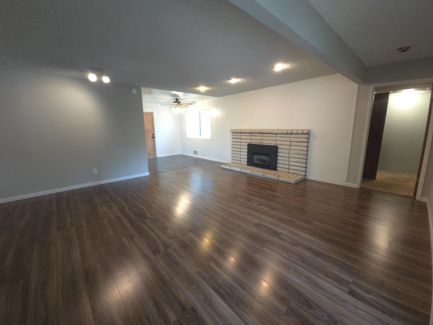 1601 Jacquelyn Way Modesto, CA 95355 - Photo 5 of 23 an empty room with wooden floor fireplace and windows