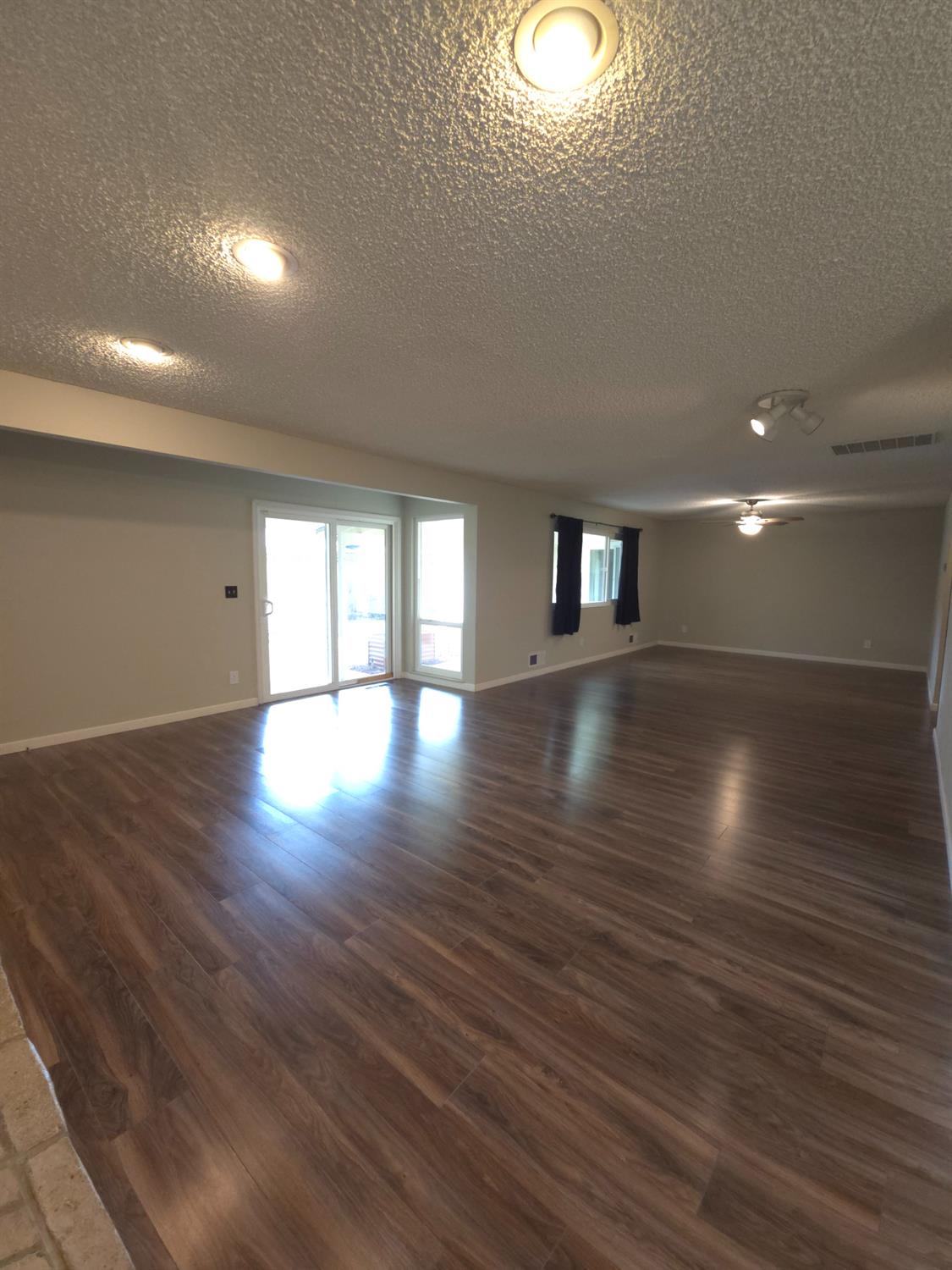 1601 Jacquelyn Way Modesto, CA 95355 - Photo 6 of 23 an empty room with wooden floor and windows