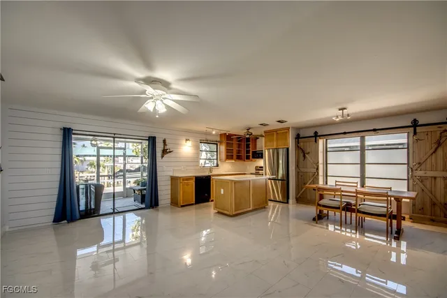 a open kitchen with stainless steel appliances granite countertop a sink and dishwasher with a dining table