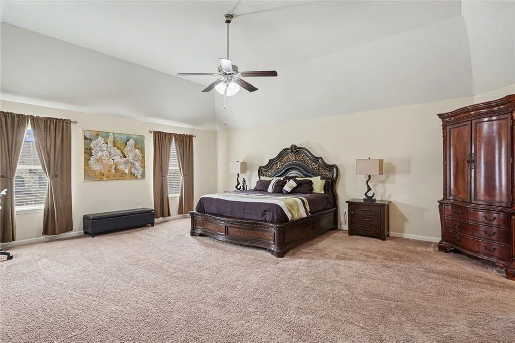 12155 Centerra Drive Hampton, GA 30228 - Photo 14 of 31 a bedroom with a bed and a chandelier