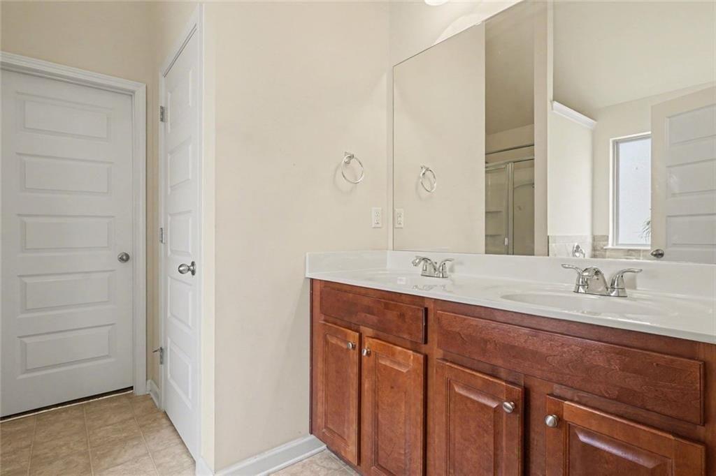 12155 Centerra Drive Hampton, GA 30228 - Photo 26 of 31 a bathroom with a double vanity sink and a mirror