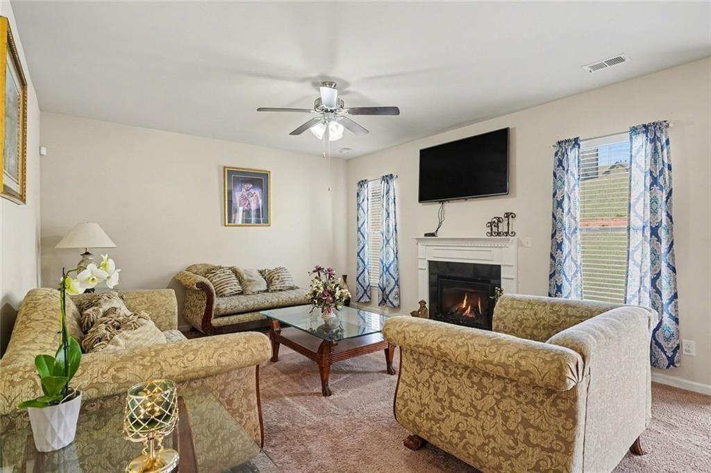 12155 Centerra Drive Hampton, GA 30228 - Photo 5 of 31 a living room with furniture a fireplace and a flat screen tv
