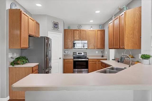 a kitchen with stainless steel appliances granite countertop a refrigerator stove top oven and sink