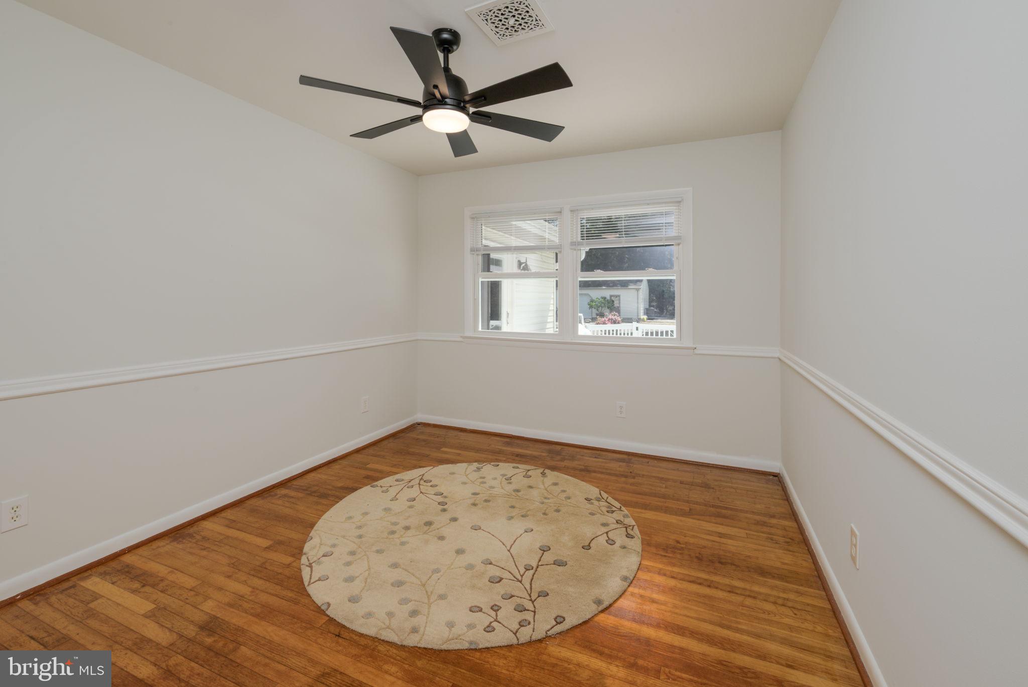 4563 Nutters Cross Road Salisbury, MD 21804 - Photo 44 of 52 an empty room with wooden floor fan and windows