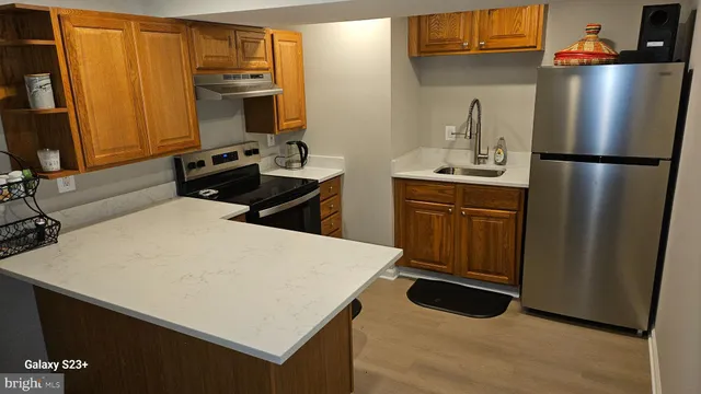 a kitchen with a refrigerator a stove top oven a sink and dishwasher