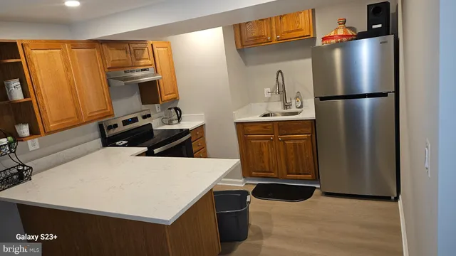 a kitchen with stainless steel appliances a stove top oven a refrigerator a sink and dishwasher