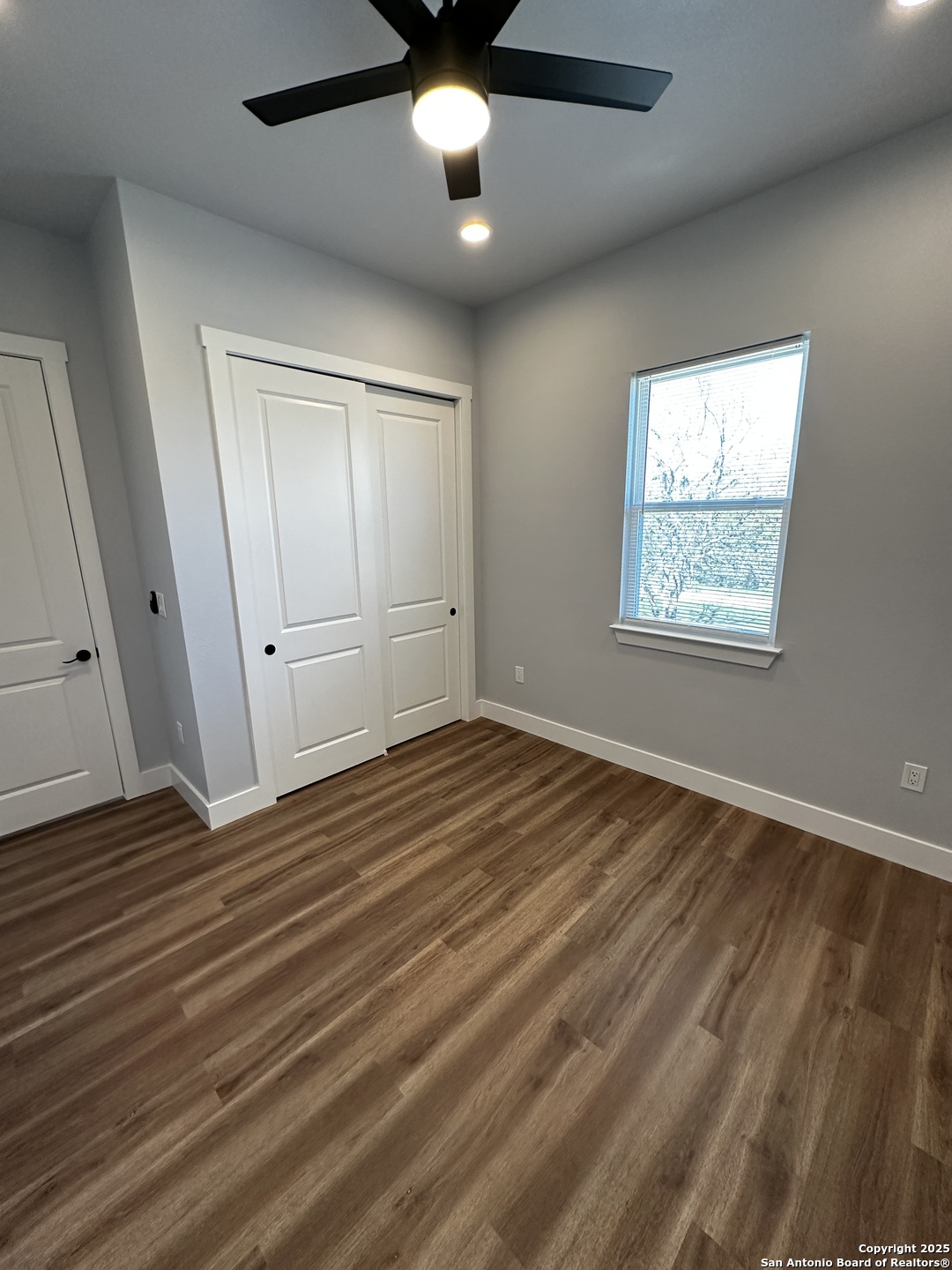 327 Ebner Street, Unit B Boerne, TX 78006 - Photo 11 of 21 wooden floor in an empty room with a window