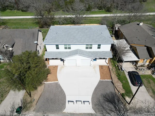 an aerial view of a house with a yard