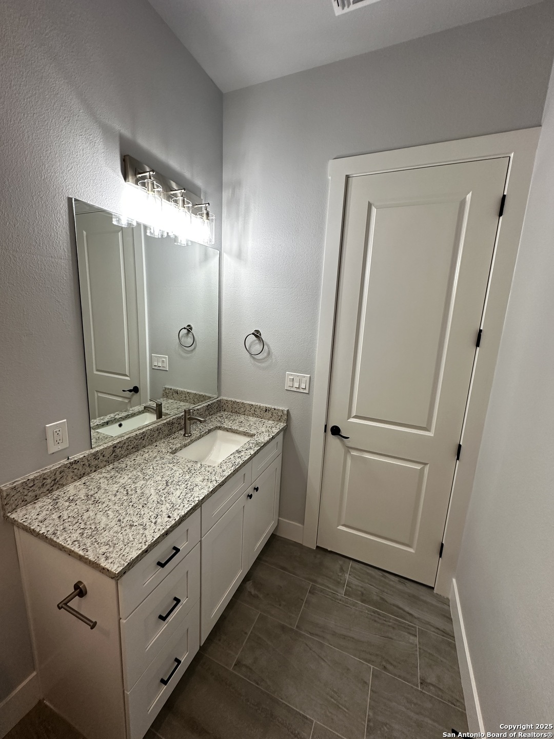 327 Ebner Street, Unit B Boerne, TX 78006 - Photo 9 of 21 a bathroom with a granite countertop sink and a mirror