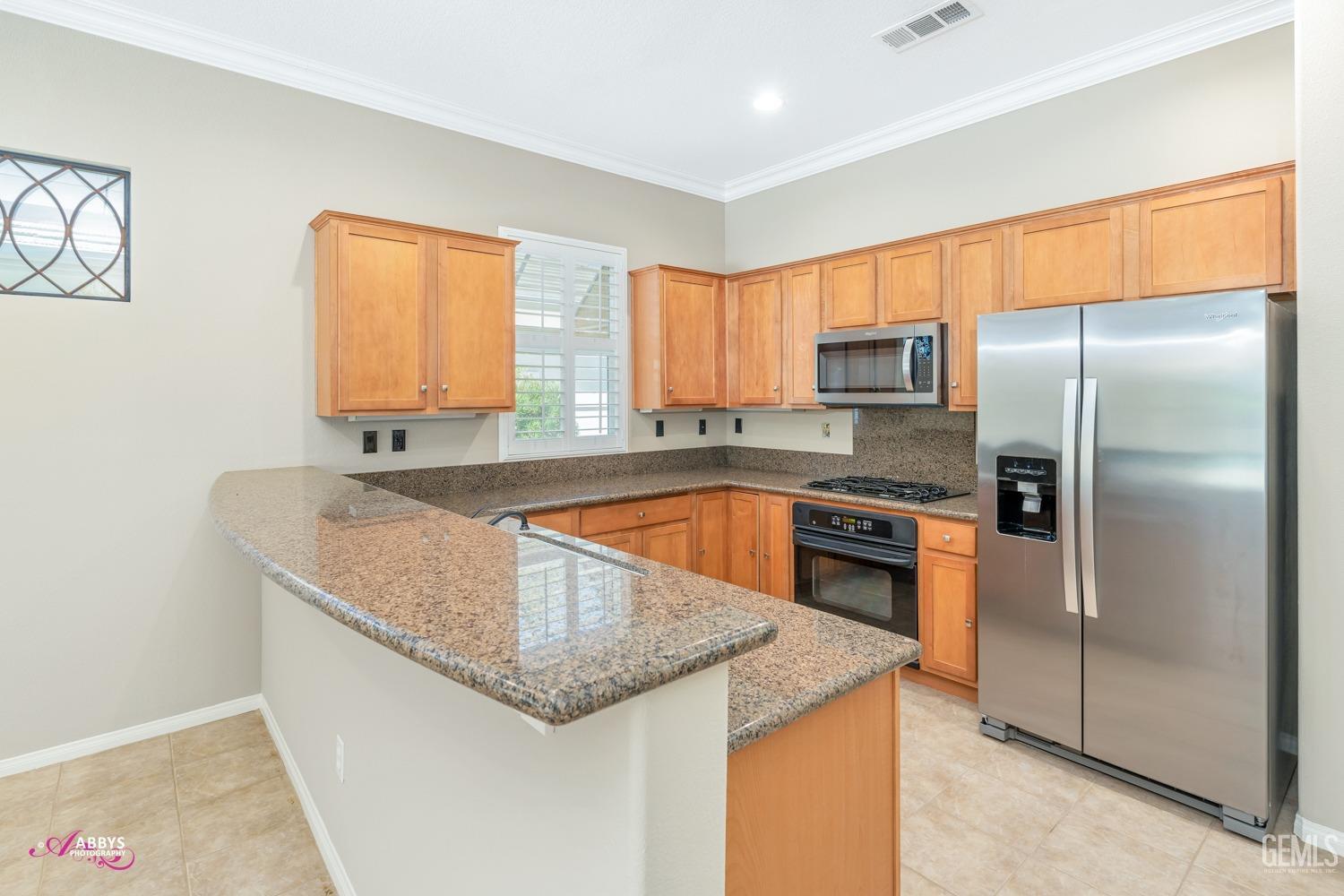 Undisclosed Address Bakersfield, CA 93306 - Photo 11 of 49 a kitchen with stainless steel appliances granite countertop a sink a stove and a refrigerator